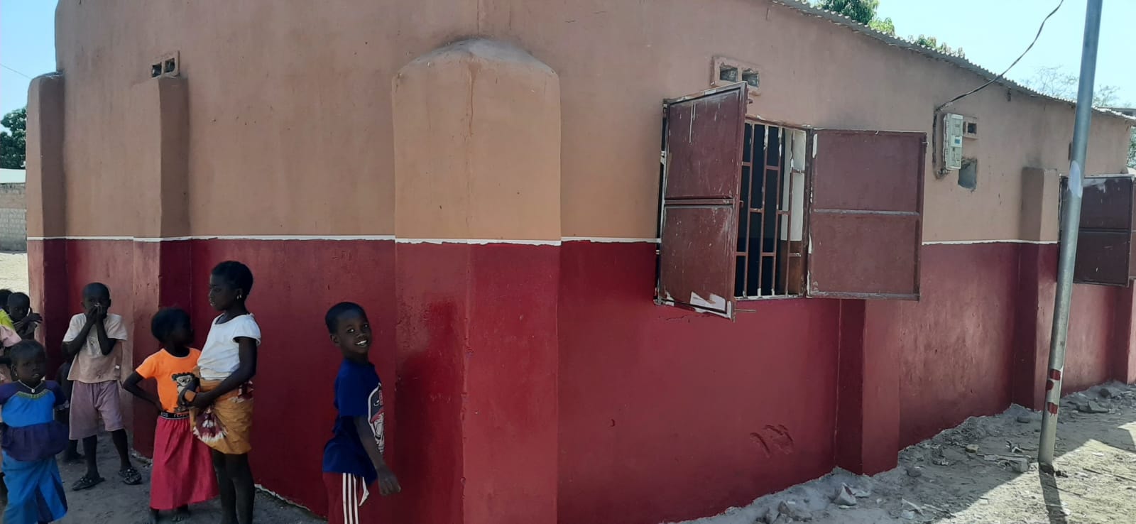 Blackhall Madrasa exterior after restoration — freshly painted walls with children outside